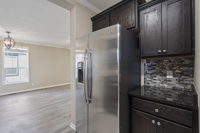 kitchen featuring crown molding, decorative backsplash, dark brown cabinets, light hardwood / wood-style floors, and stainless steel fridge with ice dispenser