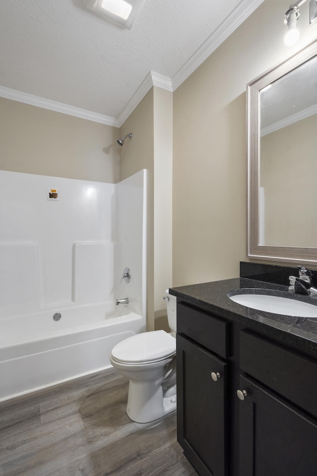 full bathroom featuring hardwood / wood-style floors, vanity, shower / washtub combination, toilet, and ornamental molding