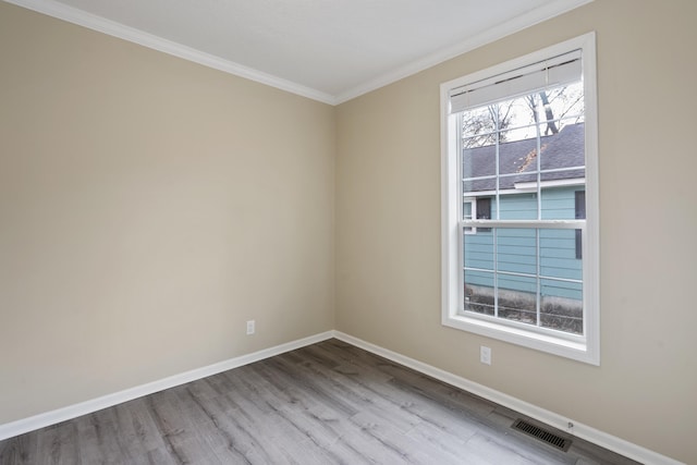 spare room with light hardwood / wood-style flooring and crown molding