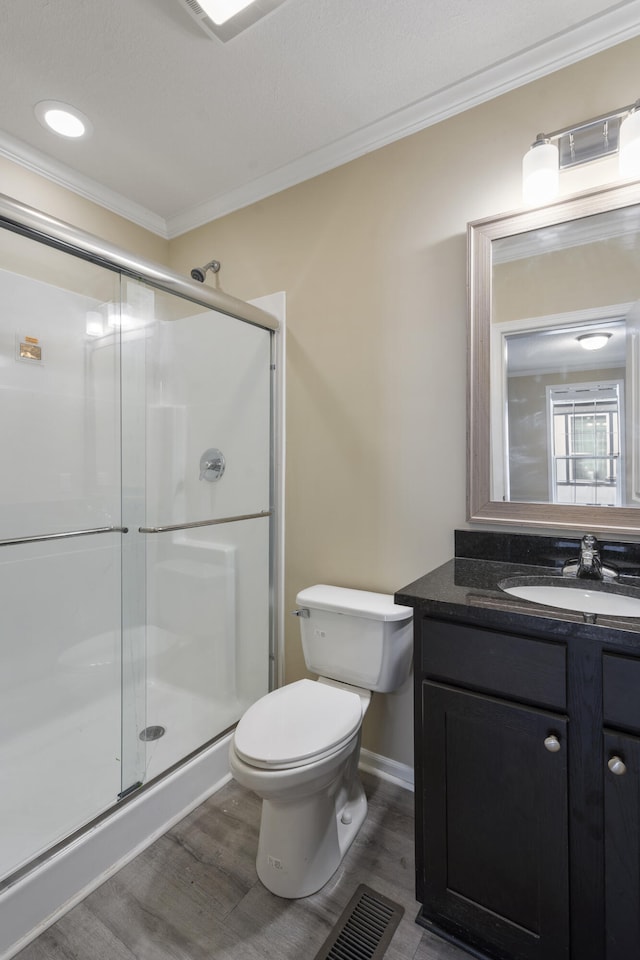 bathroom with vanity, an enclosed shower, wood-type flooring, and ornamental molding