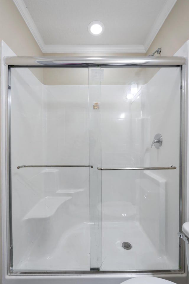 bathroom featuring crown molding and a shower with shower door