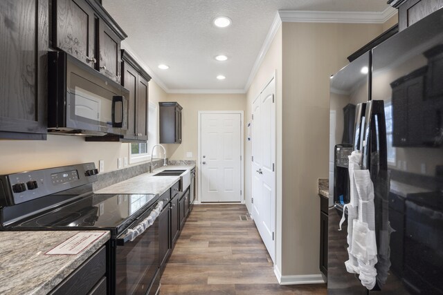 kitchen with black appliances, dark brown cabinets, dark hardwood / wood-style flooring, and sink