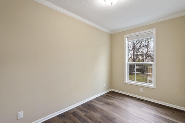 empty room with a textured ceiling, crown molding, and dark wood-type flooring