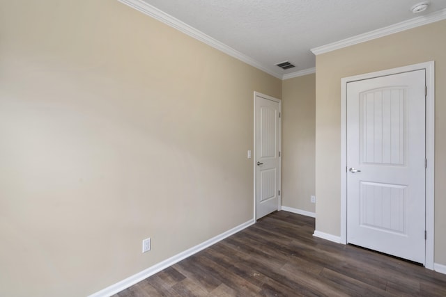 unfurnished bedroom featuring a textured ceiling, ornamental molding, and dark wood-type flooring