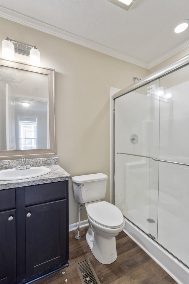 bathroom with an enclosed shower, toilet, hardwood / wood-style flooring, vanity, and ornamental molding