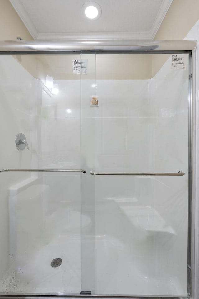 bathroom featuring crown molding and walk in shower