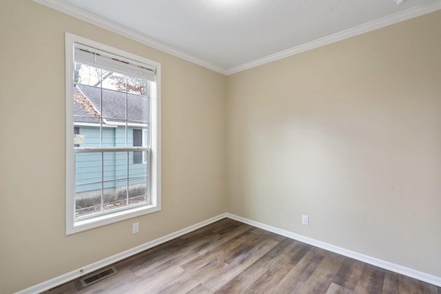 spare room with hardwood / wood-style floors, ornamental molding, and a textured ceiling