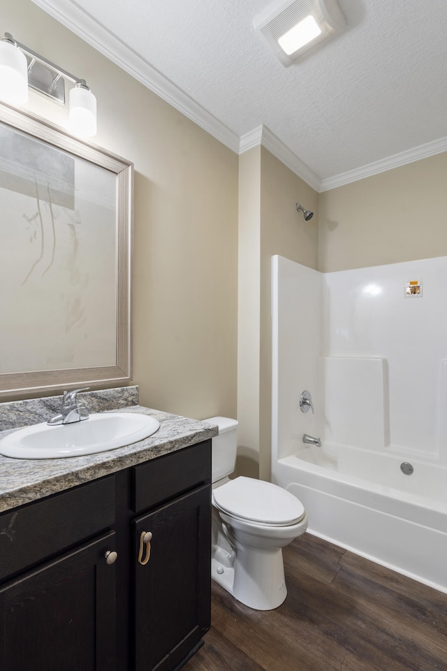 full bathroom with wood-type flooring, a textured ceiling, toilet, shower / bathtub combination, and ornamental molding