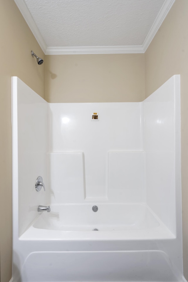 bathroom featuring tub / shower combination, a textured ceiling, and crown molding