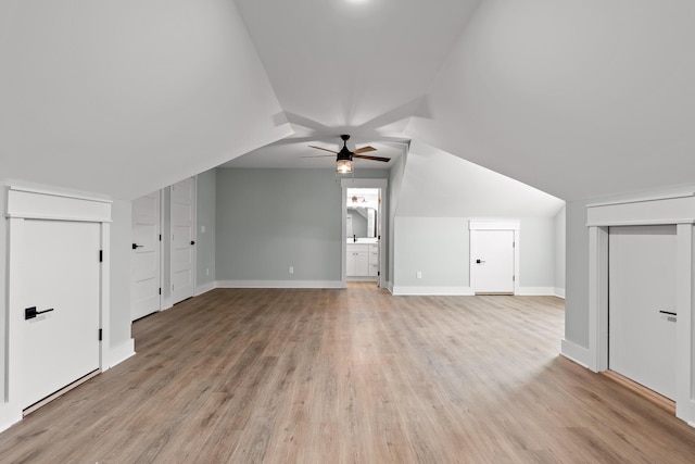 additional living space with ceiling fan, light wood-type flooring, and vaulted ceiling