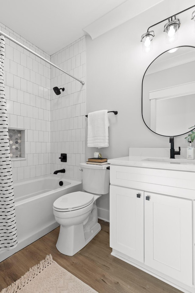 full bathroom featuring hardwood / wood-style floors, vanity, shower / bath combo, and toilet