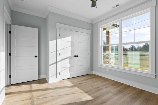 entryway with plenty of natural light, light hardwood / wood-style floors, ornamental molding, and ceiling fan