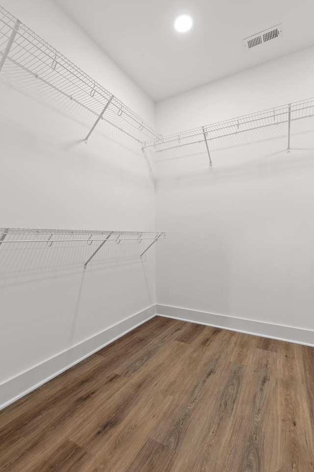 walk in closet with hardwood / wood-style floors