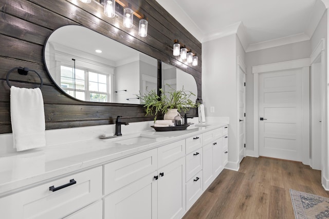 bathroom featuring hardwood / wood-style floors, vanity, and ornamental molding