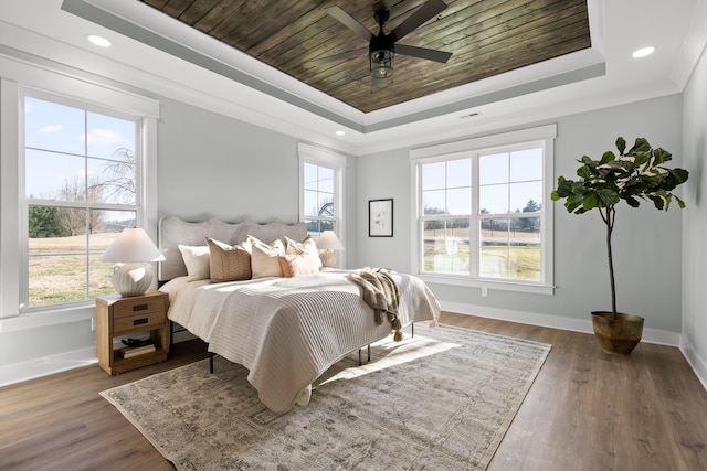 bedroom with ceiling fan, a raised ceiling, ornamental molding, and dark wood-type flooring