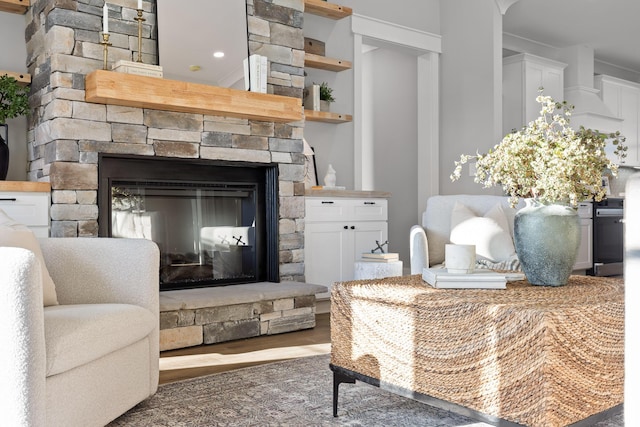 interior space with wood-type flooring and a stone fireplace