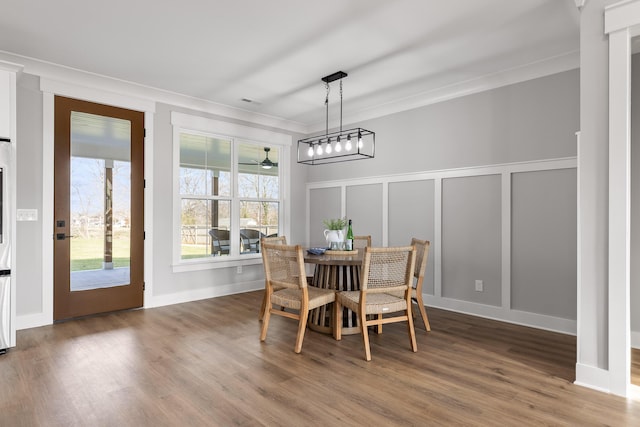 dining area with hardwood / wood-style floors and ornamental molding