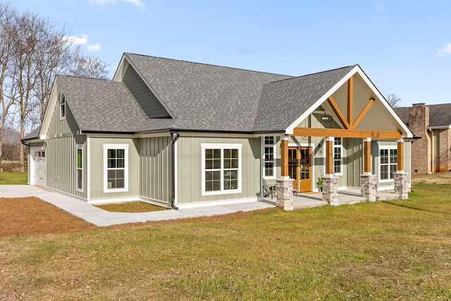 rear view of house featuring a yard and a garage