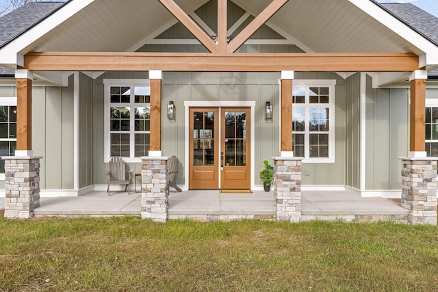 entrance to property with covered porch, french doors, and a lawn