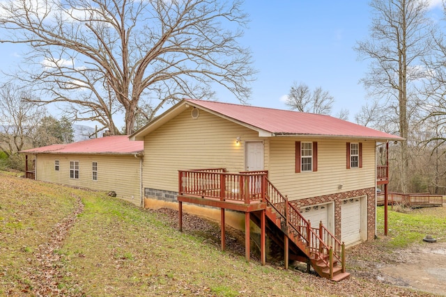 back of house featuring a wooden deck, a yard, and a garage