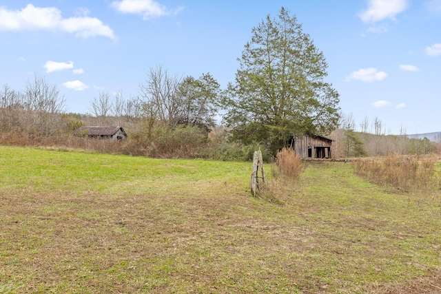 view of yard with a rural view and an outdoor structure