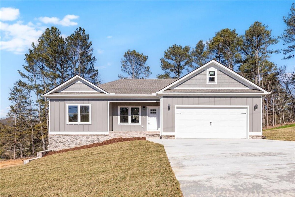 ranch-style house with a garage and a front lawn