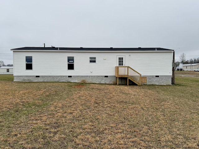 back of property with a yard and crawl space