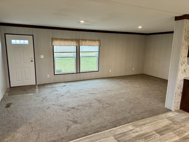 unfurnished living room featuring ornamental molding, recessed lighting, visible vents, and light carpet