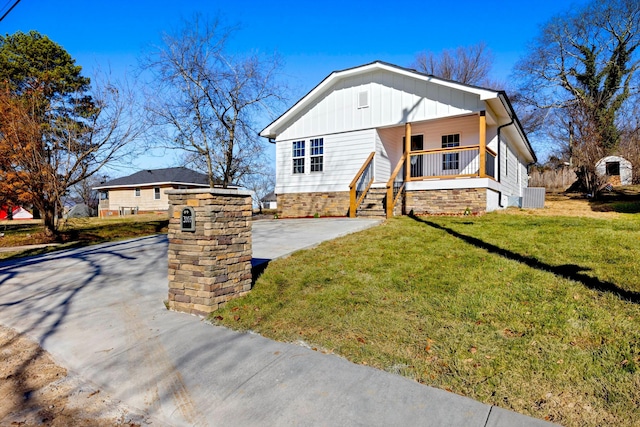 view of front of house featuring covered porch, a front yard, and central AC