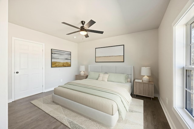 bedroom featuring ceiling fan, radiator heating unit, and dark wood-type flooring