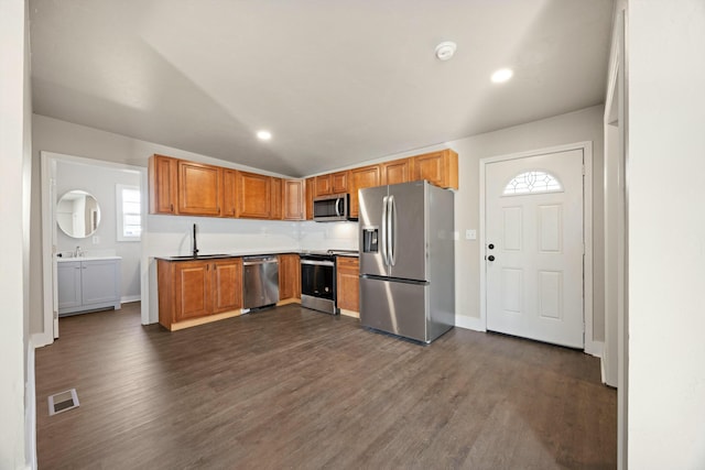 kitchen with tasteful backsplash, sink, dark hardwood / wood-style flooring, and appliances with stainless steel finishes