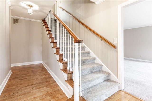 stairway featuring hardwood / wood-style flooring and ornamental molding