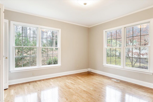 unfurnished room featuring plenty of natural light, light hardwood / wood-style floors, and ornamental molding