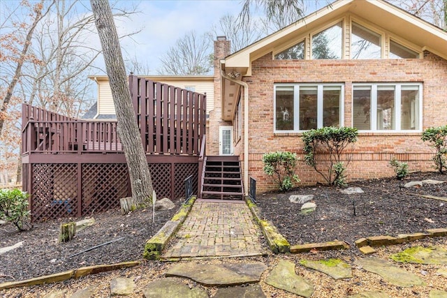 rear view of house featuring a wooden deck