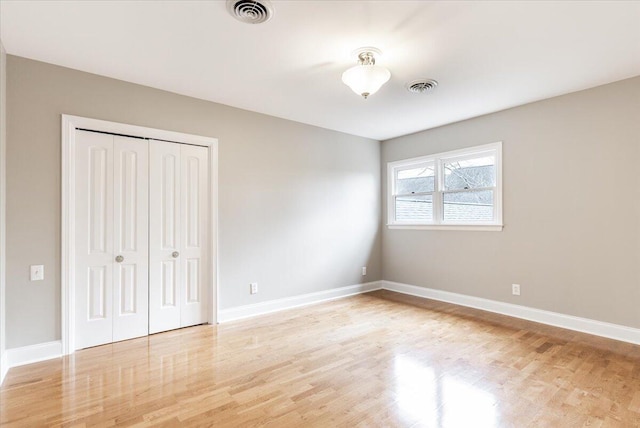 unfurnished bedroom featuring a closet and light hardwood / wood-style flooring