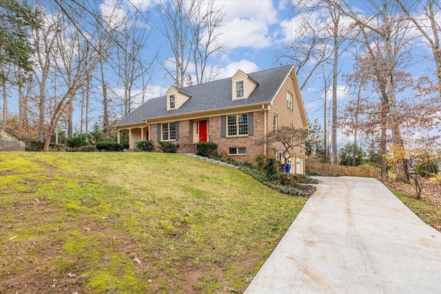 cape cod-style house with a front yard