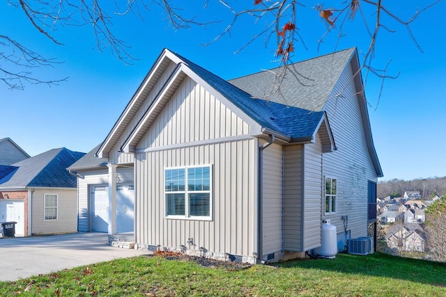 view of front of home with cooling unit, a front lawn, and a garage