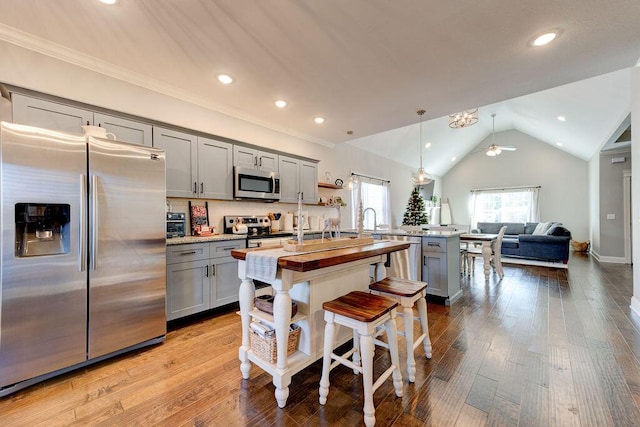 kitchen featuring appliances with stainless steel finishes, gray cabinetry, ceiling fan, pendant lighting, and lofted ceiling