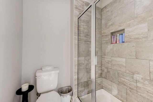 bathroom with toilet and an enclosed shower