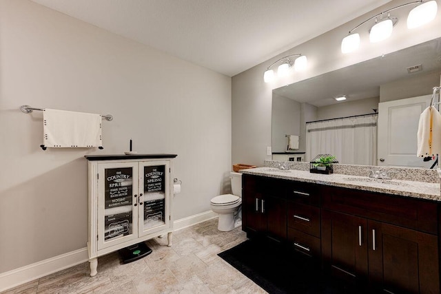 bathroom with vanity, curtained shower, and toilet