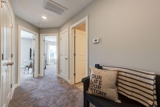 hallway featuring light colored carpet