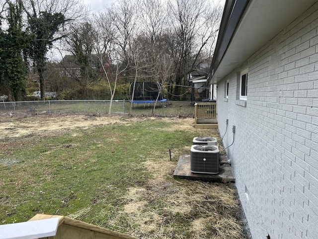 view of yard featuring central air condition unit and a trampoline