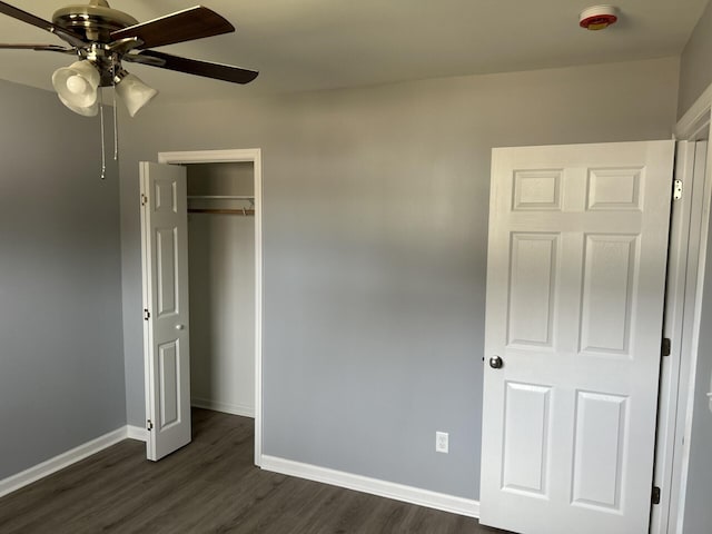 unfurnished bedroom with ceiling fan, dark wood-type flooring, and a closet