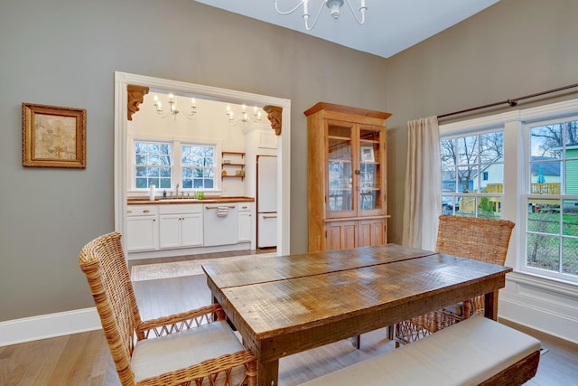 dining room featuring hardwood / wood-style floors, sink, and a chandelier