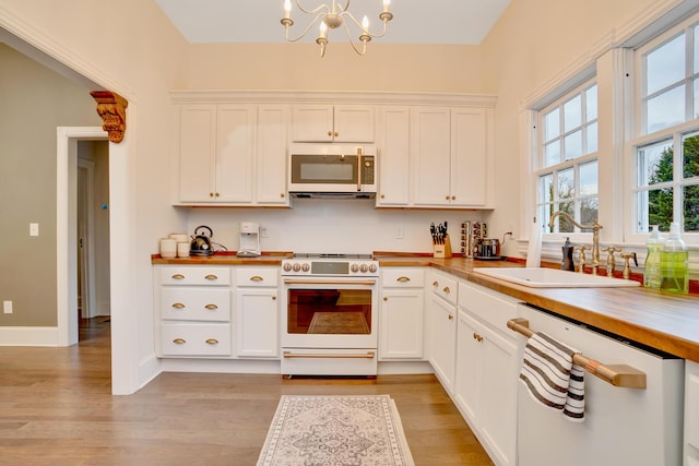 kitchen featuring white cabinetry, white appliances, and sink