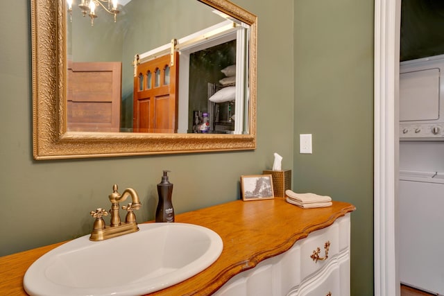 bathroom featuring vanity and stacked washer / dryer