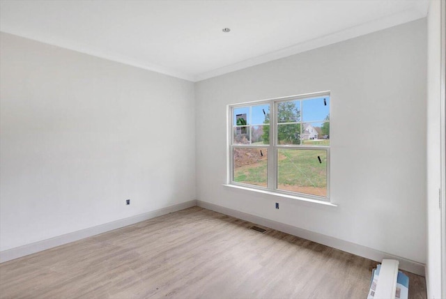 spare room featuring light hardwood / wood-style floors and ornamental molding