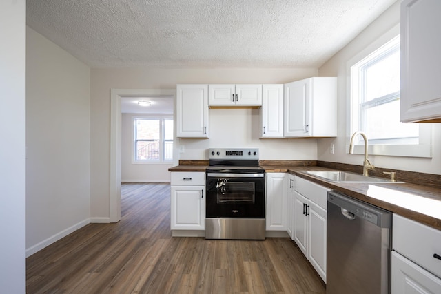 kitchen with a textured ceiling, white cabinetry, sink, and appliances with stainless steel finishes