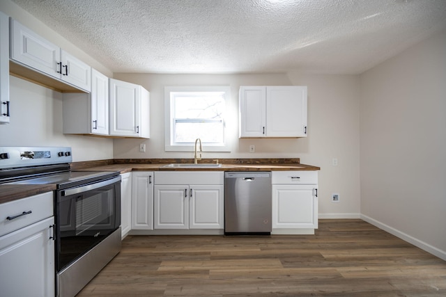 kitchen featuring a textured ceiling, stainless steel appliances, sink, dark hardwood / wood-style floors, and white cabinetry