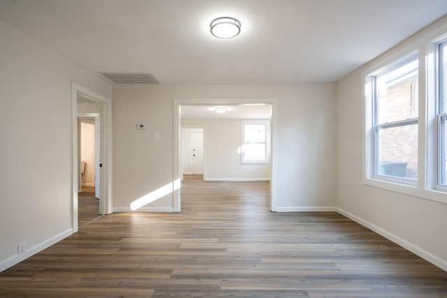 unfurnished room with dark wood-type flooring